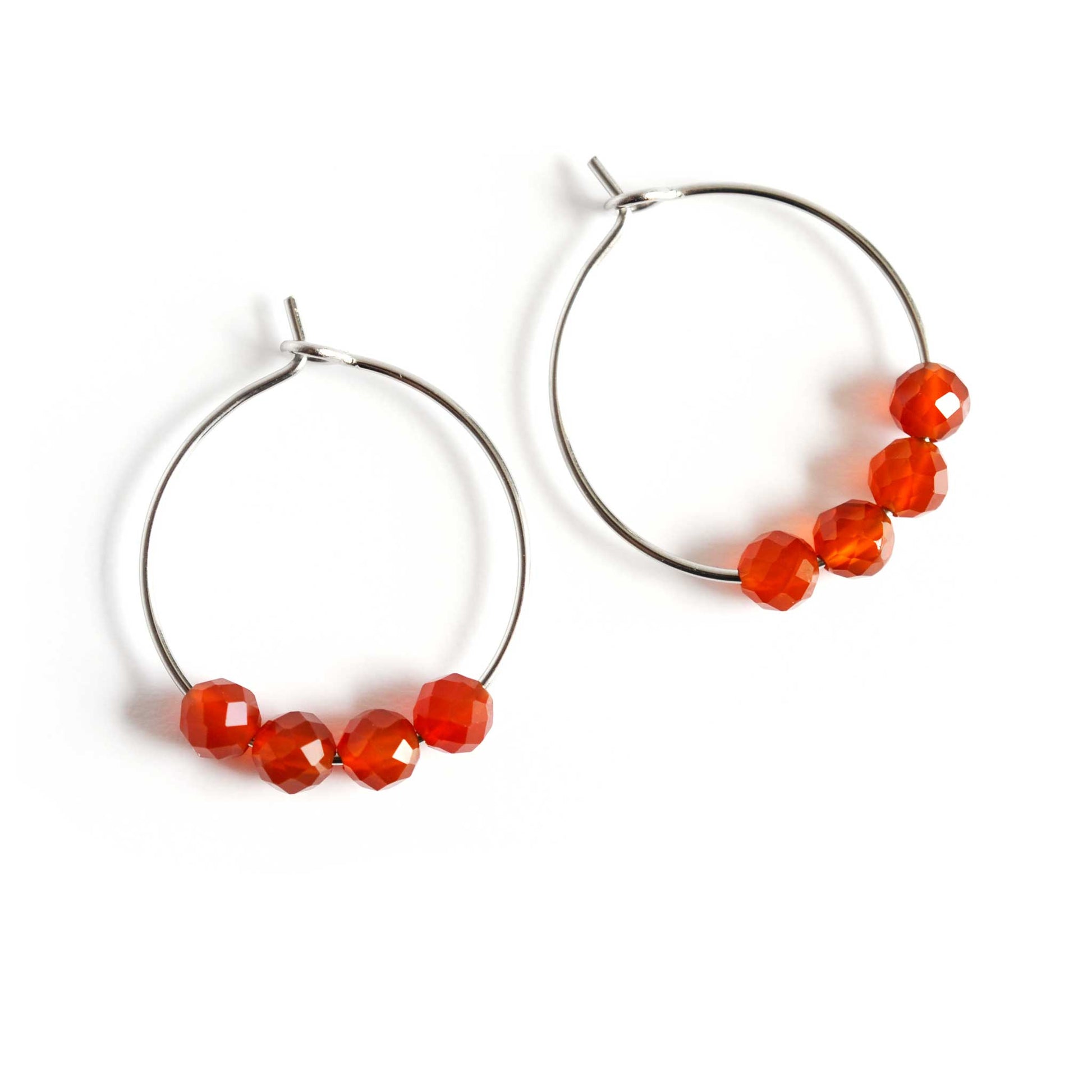 Pair of orange Carnelian gemstone hoop earrings on white background