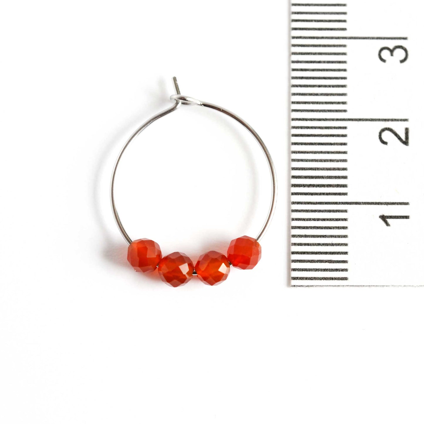 2cm diameter Carnelian gemstone hoop earring next to ruler