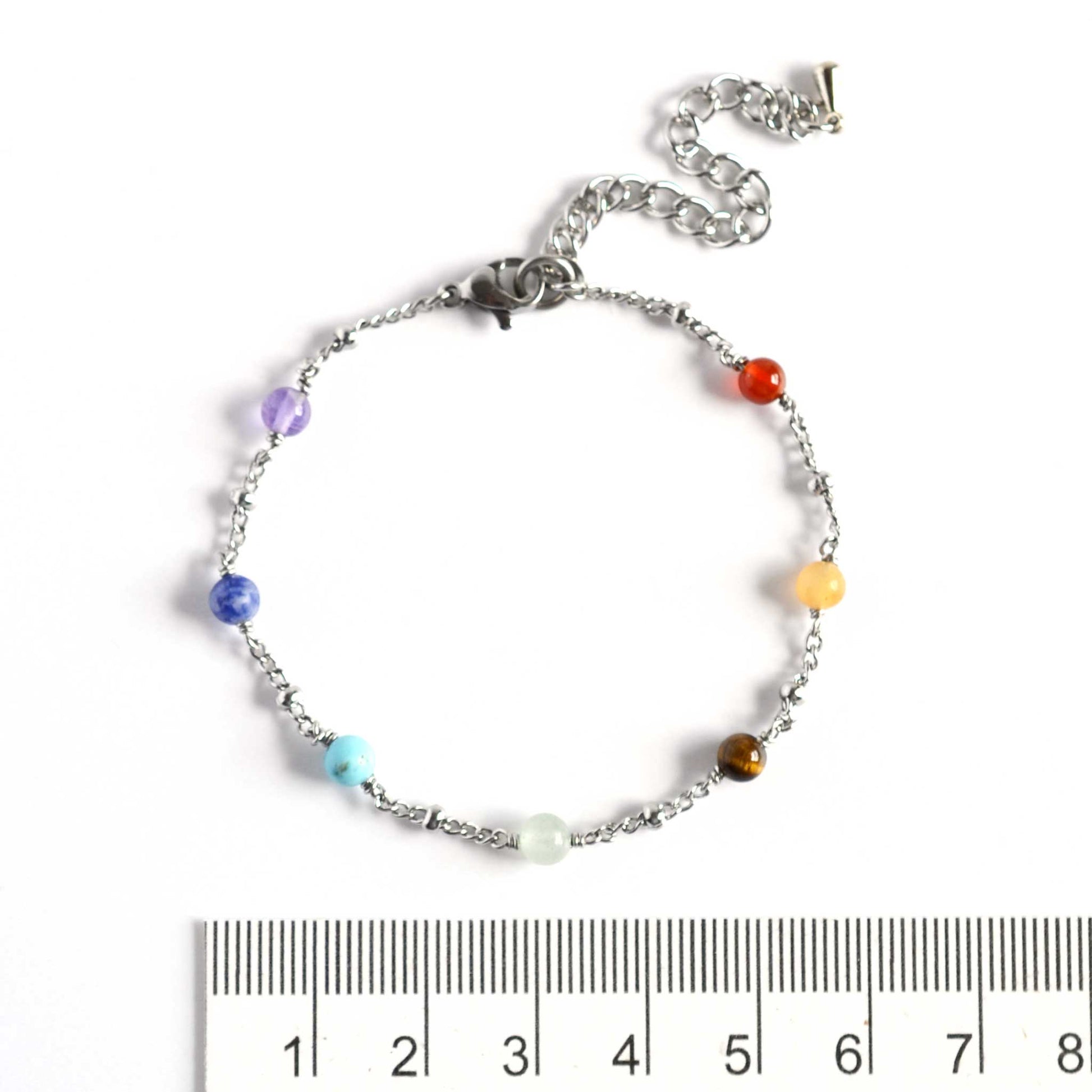 Dainty chakra bracelet with 4mm gemstone beads next to ruler