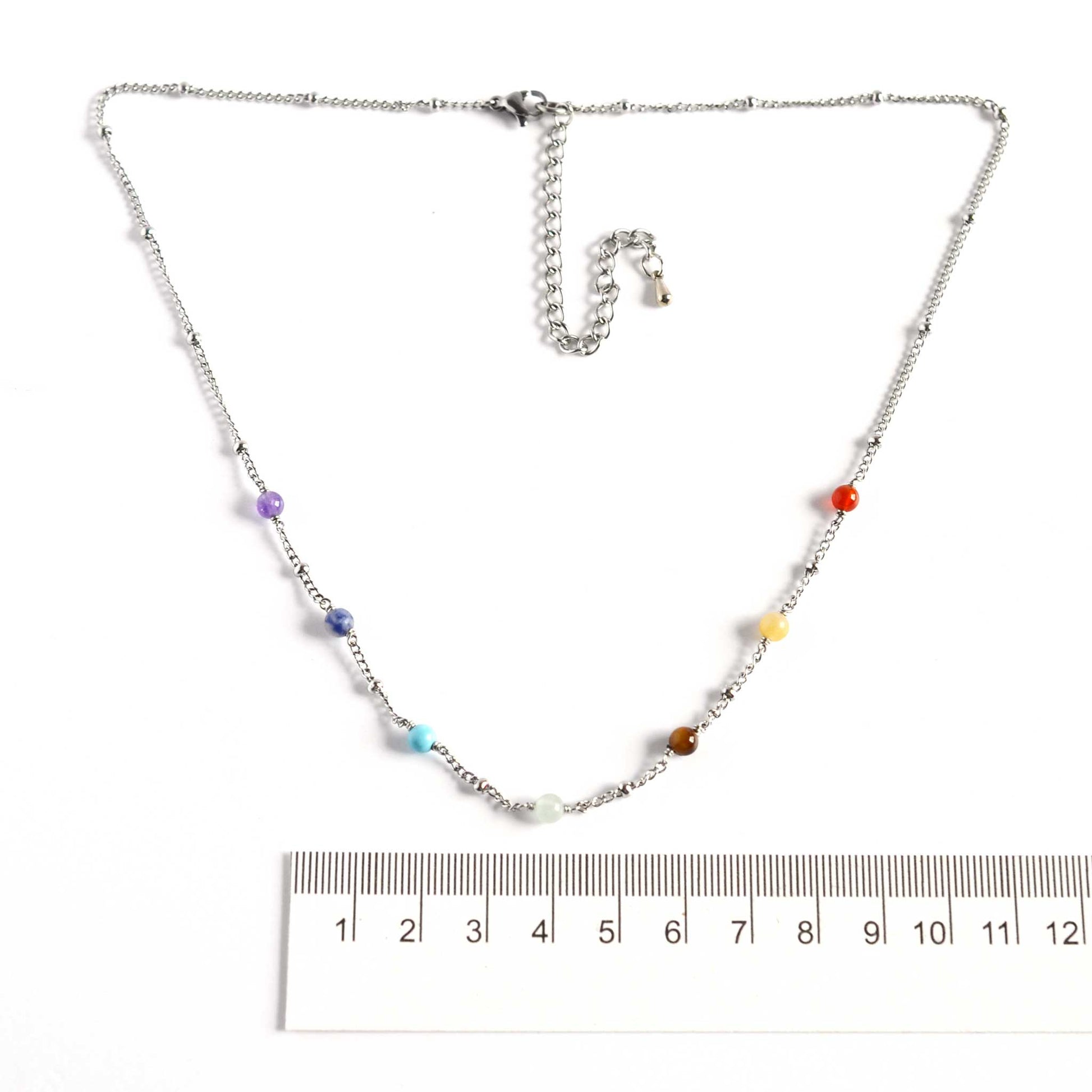 Dainty chakra necklace with 4mm gemstone beads next to ruler