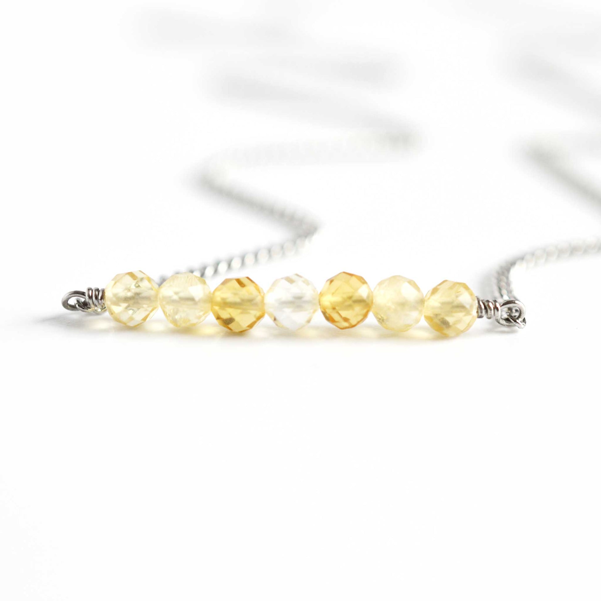 Close up of Citrine crystal necklace with seven small round faceted pale yellow Citrine beads