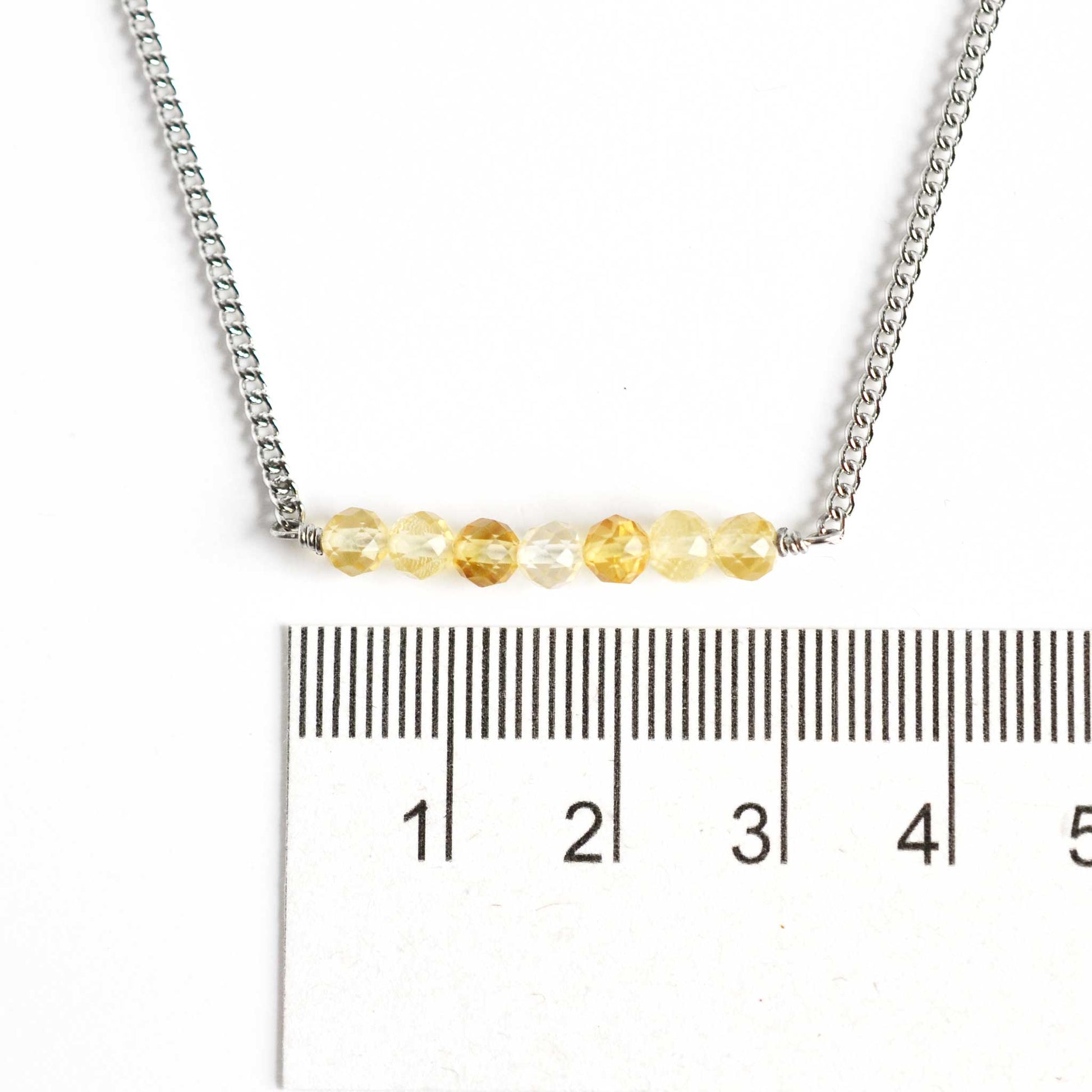 Dainty Citrine crystal necklace with 4mm Citrine gemstone beads next to ruler