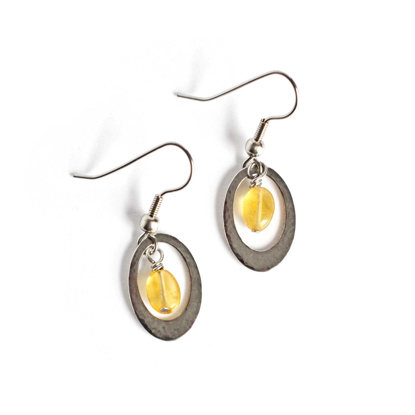 Hammered oval and yellow Citrine gemstone drop earrings on white background.