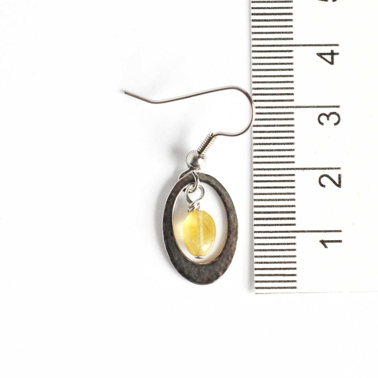 35mm long Citrine gemstone oval drop earrings next to ruler.