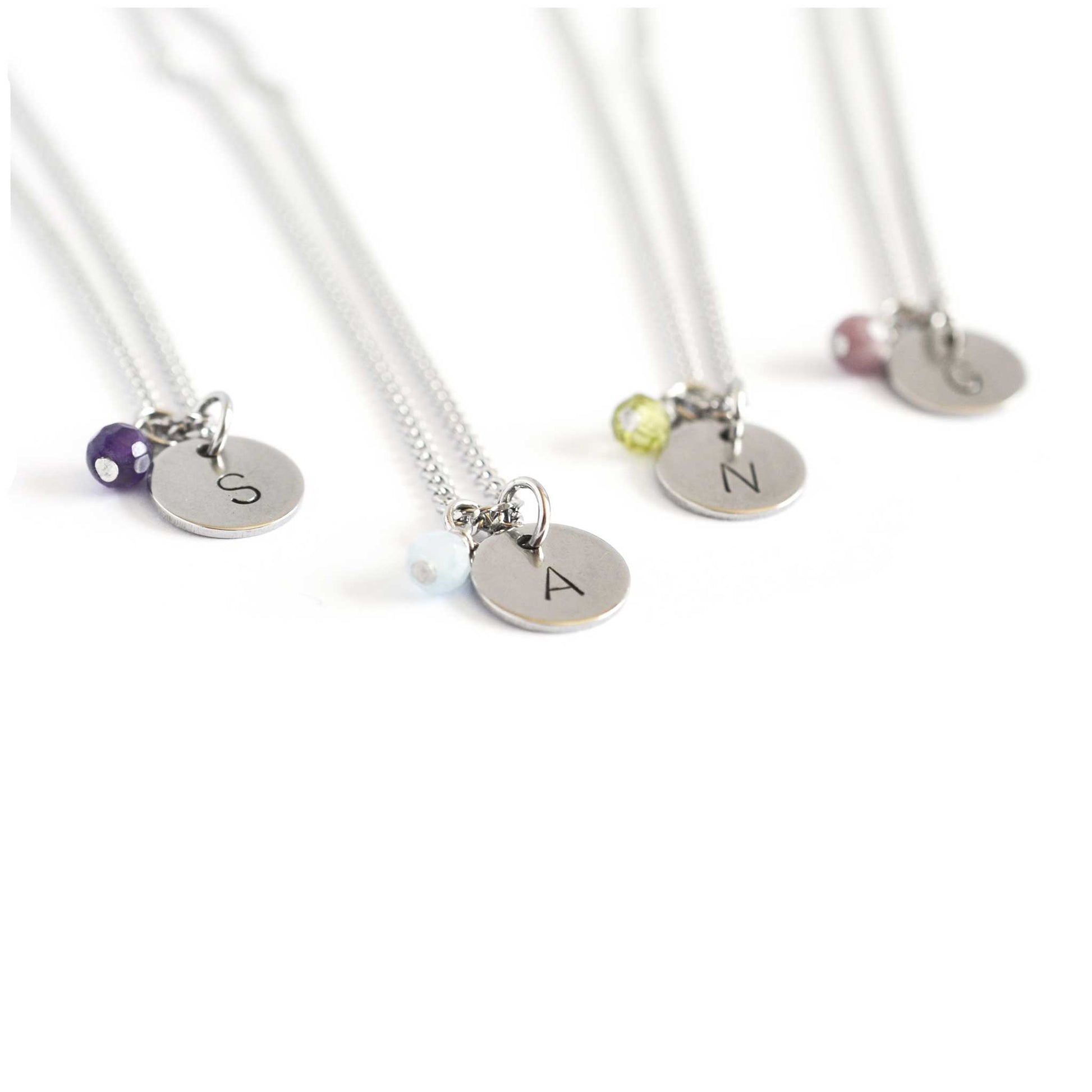 Detail view of birthstone necklaces with hand stamped initials