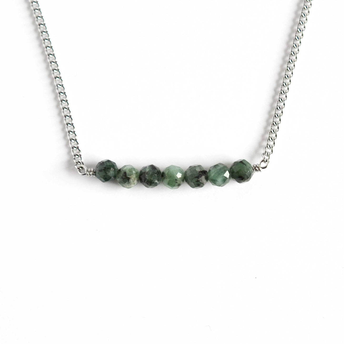 Dainty necklace with Emerald stones on white background