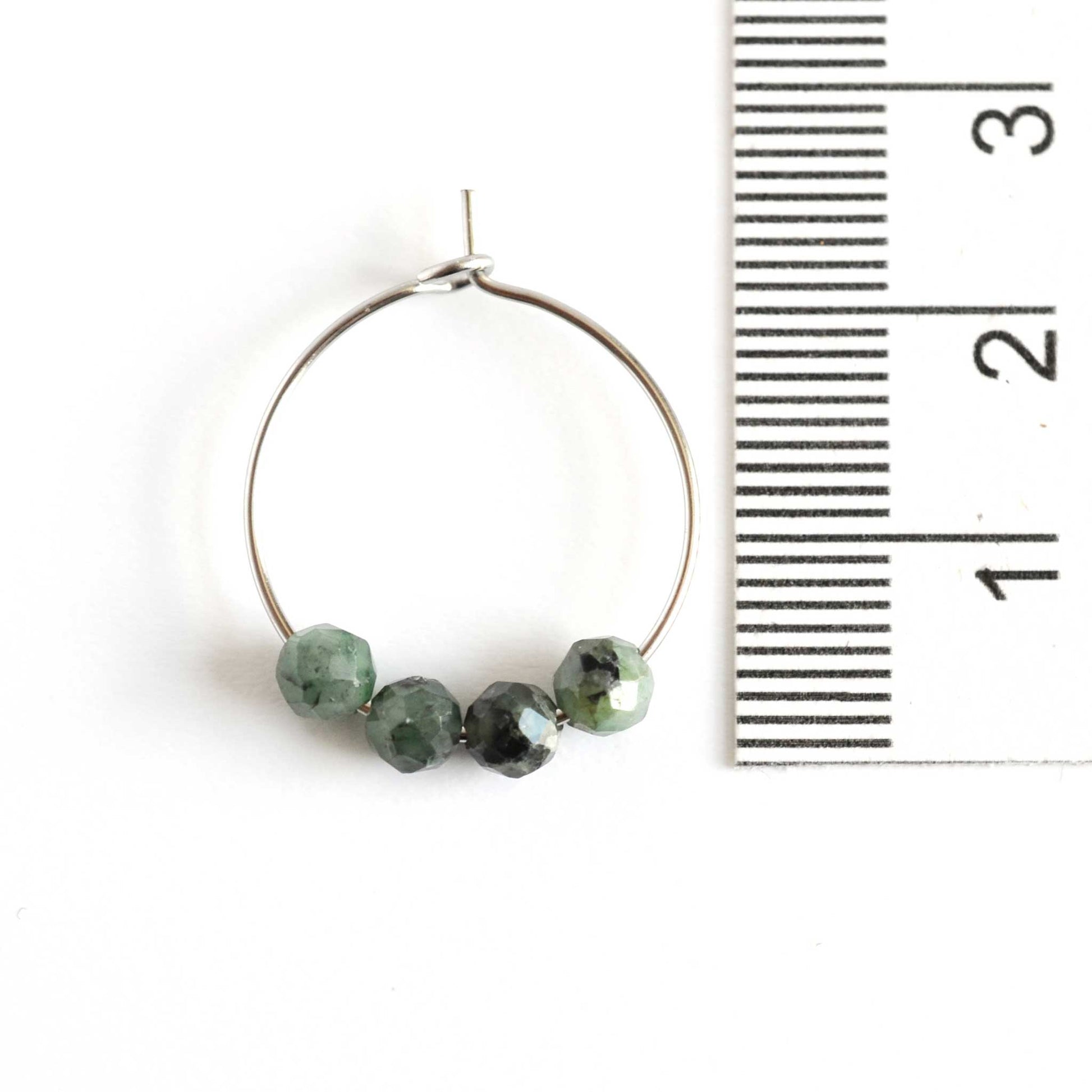 2cm diameter Emerald hoop earring next to ruler