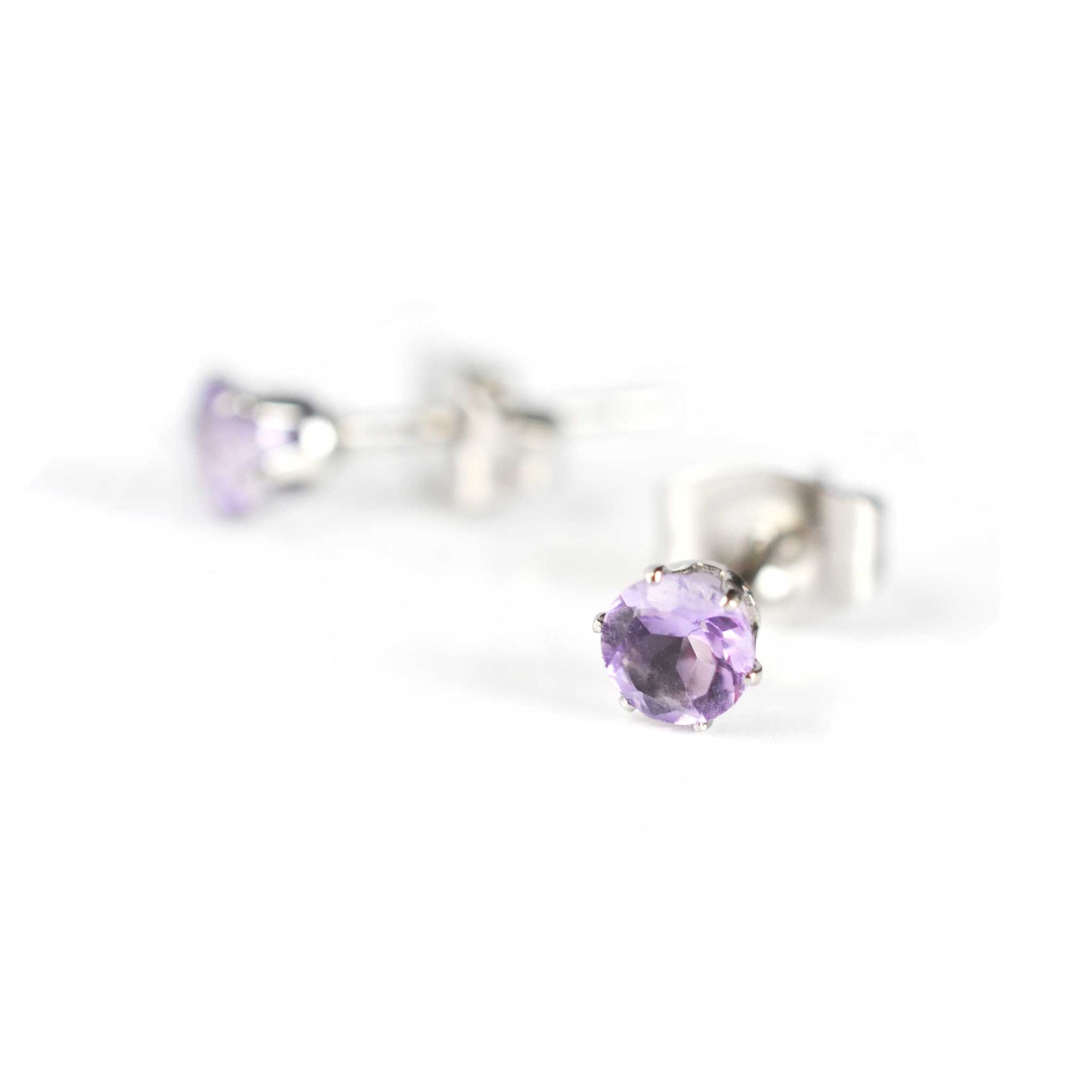 Tiny purple Amethyst stud earrings on white background