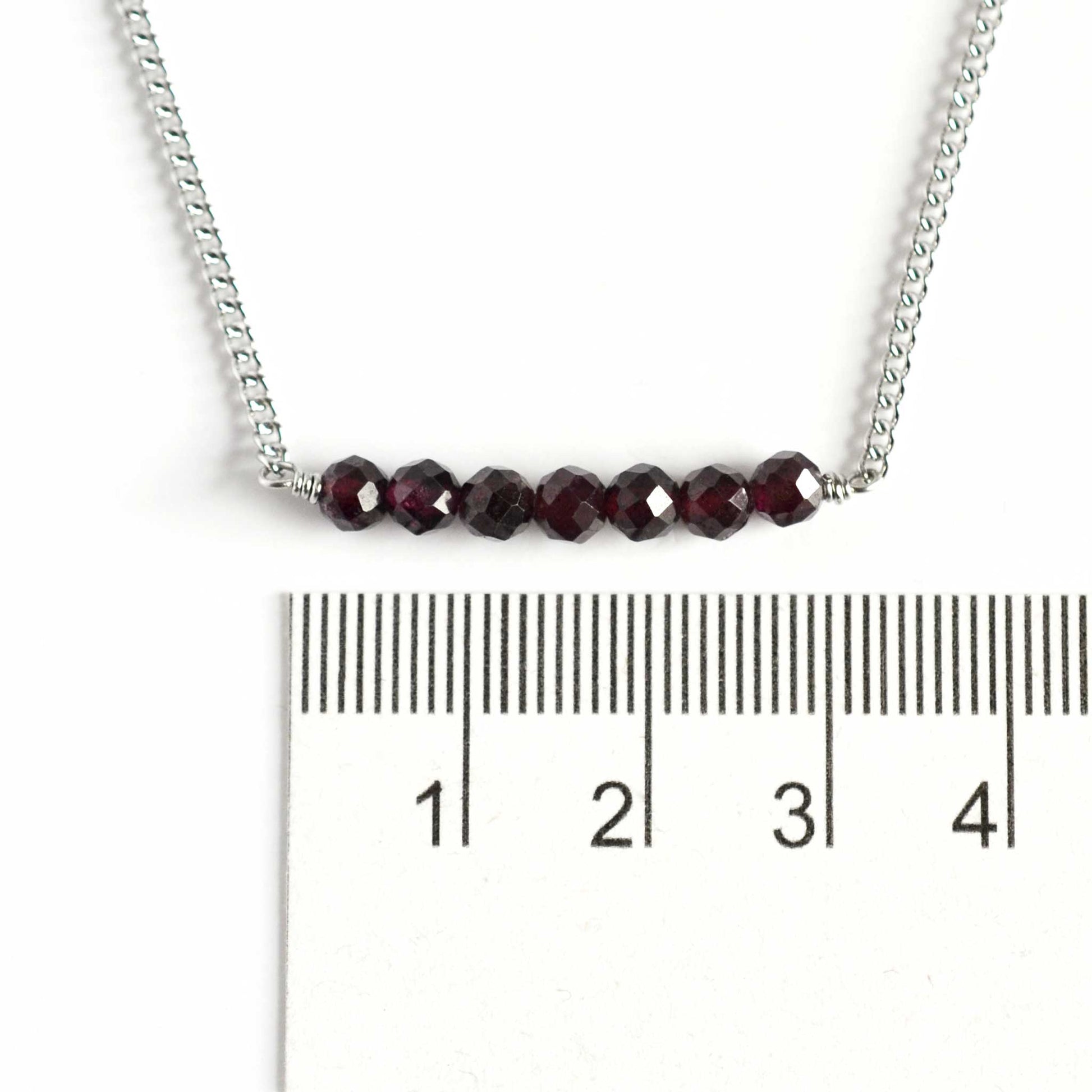 Dainty Garnet crystal necklace with 4mm gemstone beads next to ruler