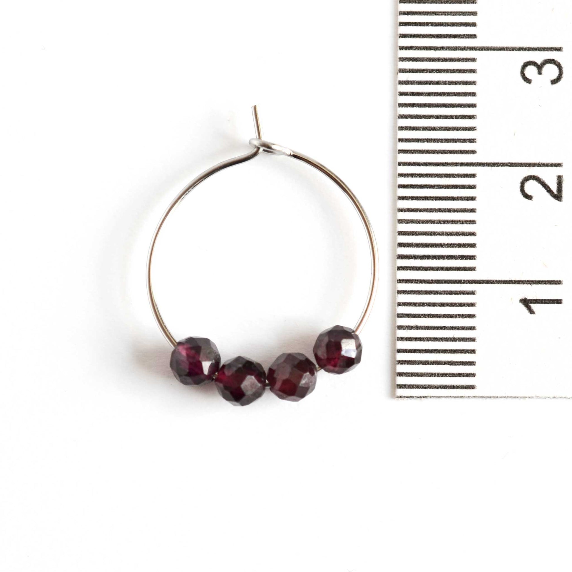 2cm diameter Garnet gemstone hoop earrings next to ruler