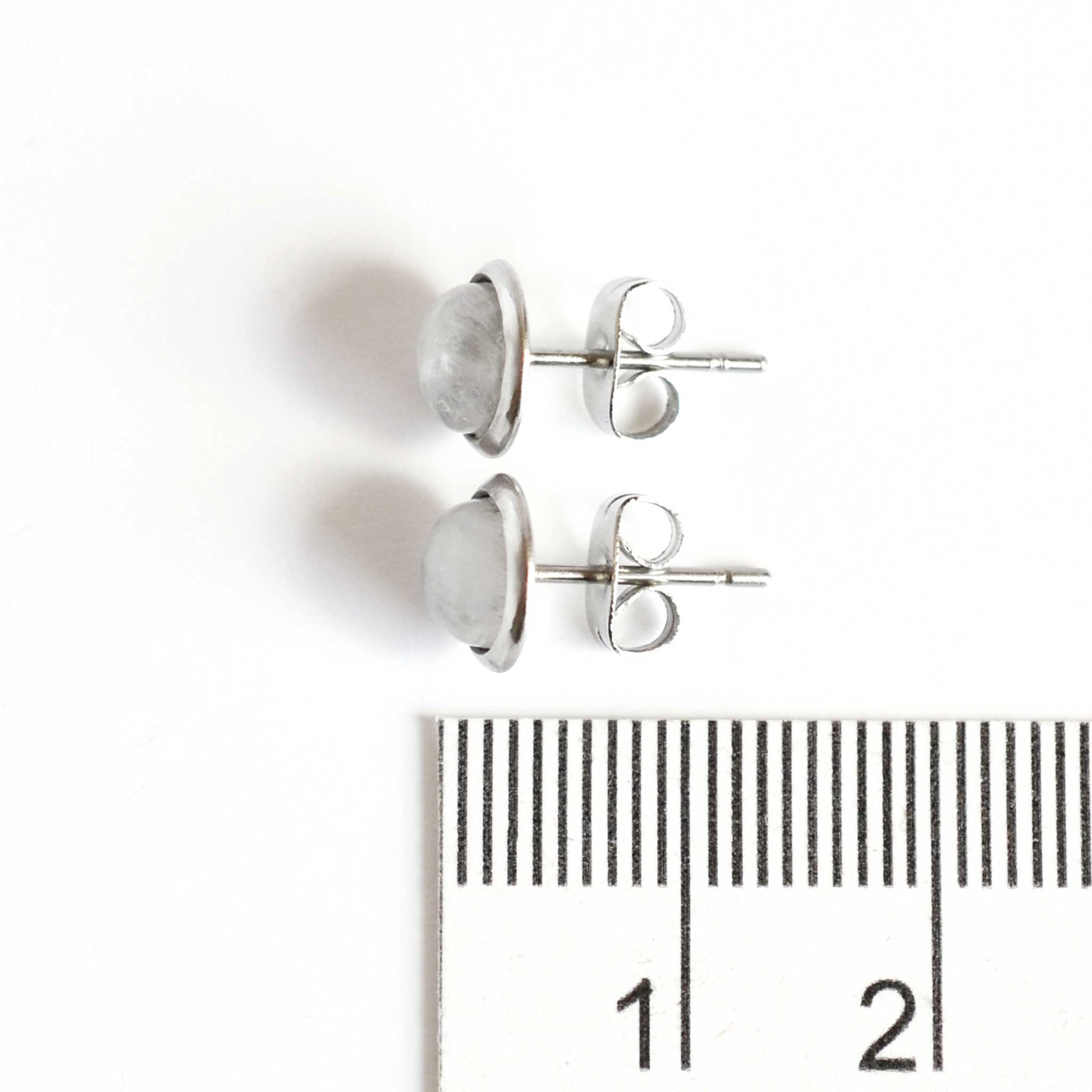 8mm diameter Rainbow Moonstone stud earrings next to ruler