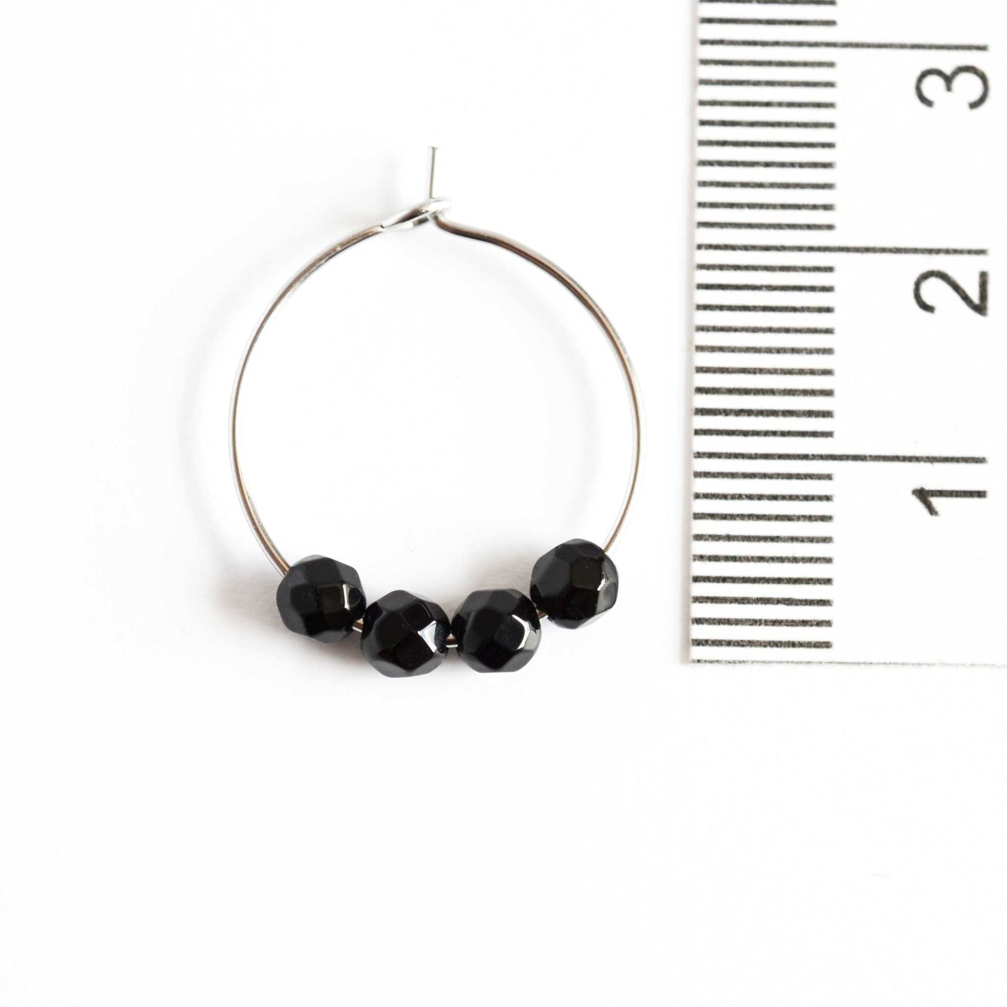 2cm diameter Onyx black hoop earrings next to ruler