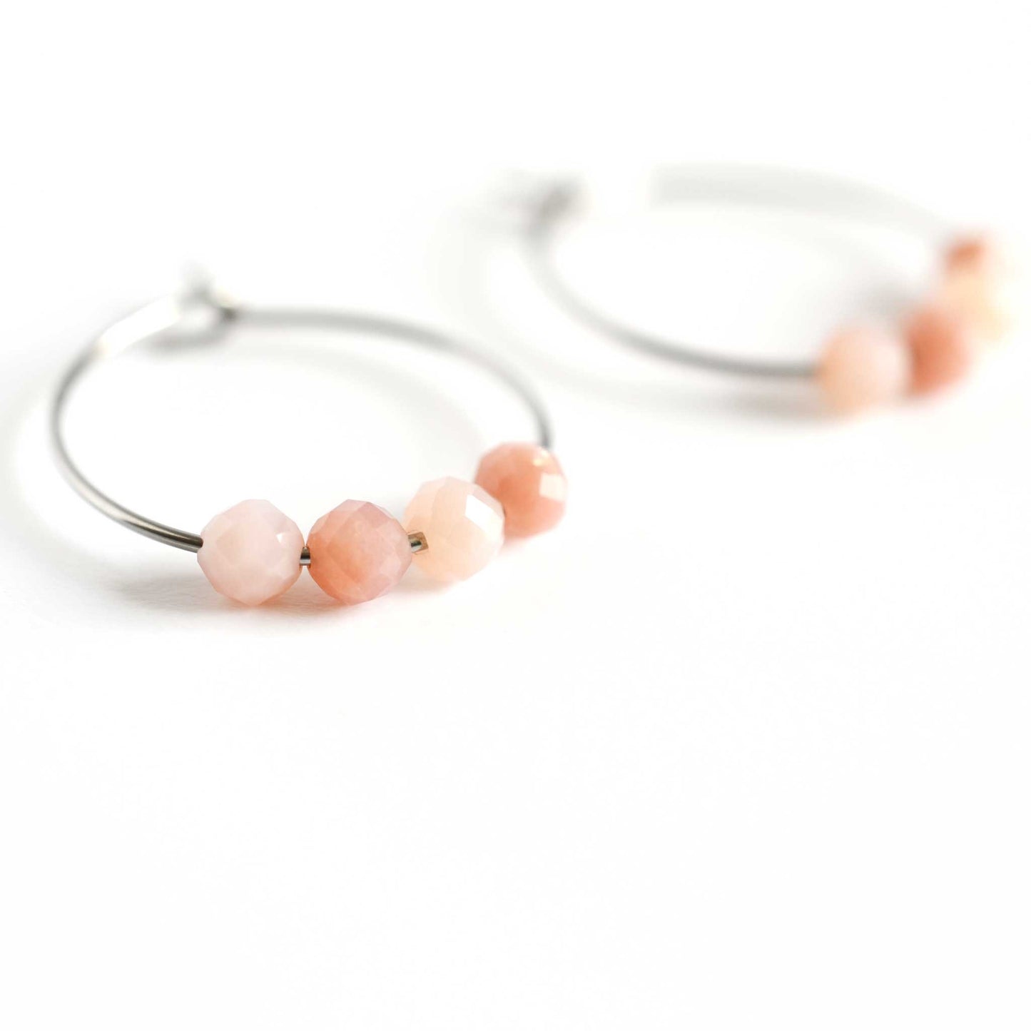 Close up of Pink Opal hoop earrings with four small round faceted Pink Opal gemstone beads