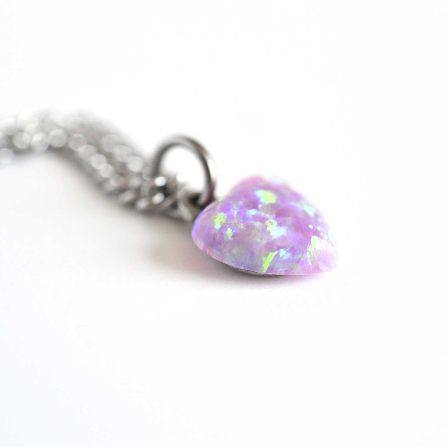 Close up of pink lab Opal heart pendant on stainless steel chain