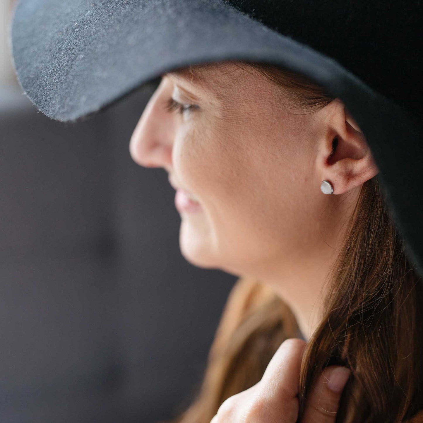 Model wearing hat and Moonstone earrings studs