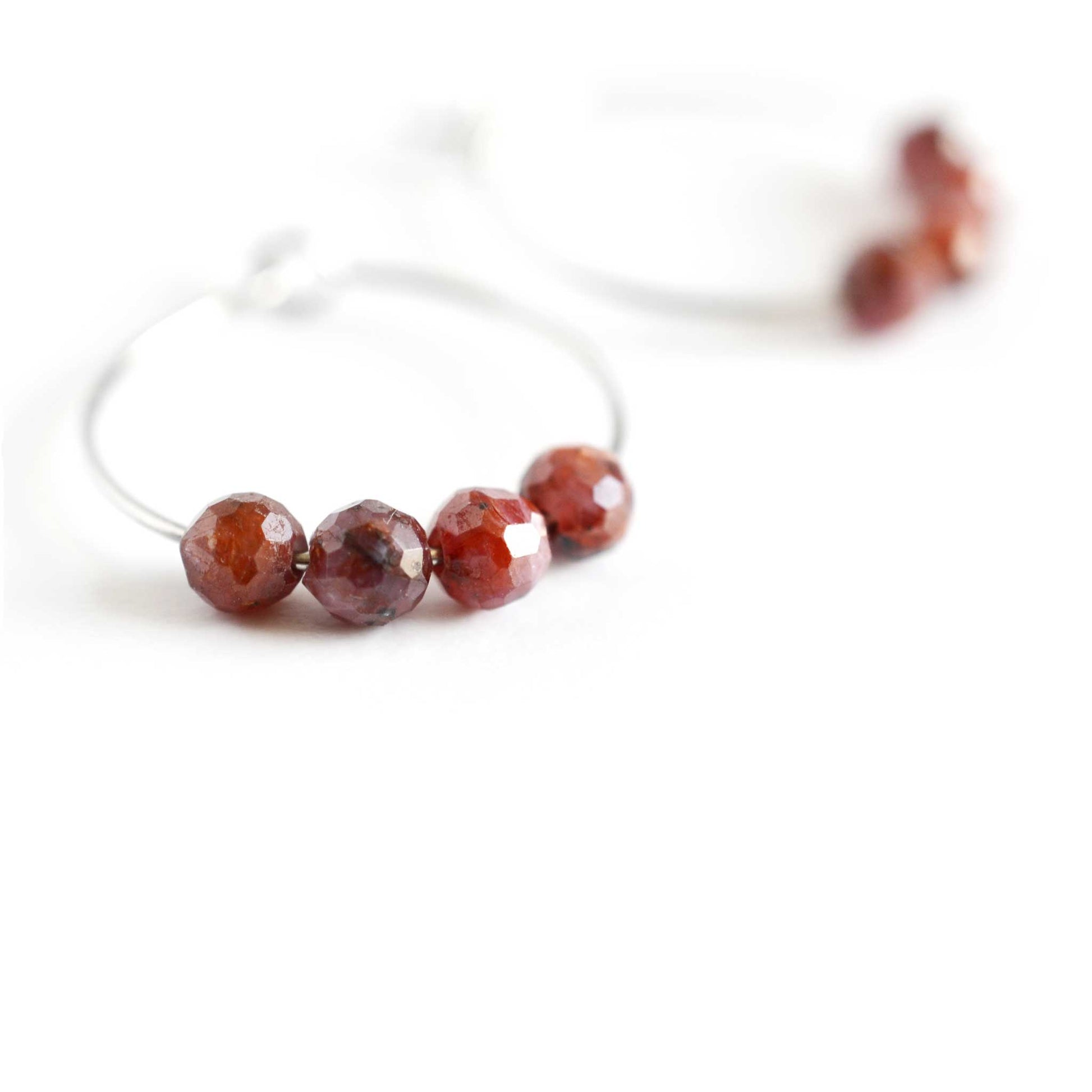 Close up of hoop earrings with Ruby stone beads