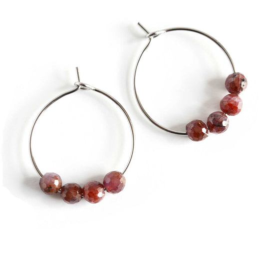 Pair of natural Ruby gemstone hoop earrings on white background