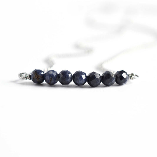 Close up of Sapphire necklace with seven dark blue round faceted natural Sapphire beads