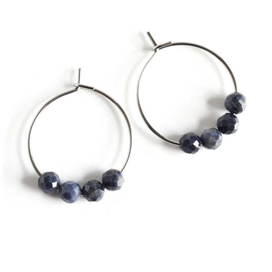 Pair of dark blue natural Sapphire earrings hoops on white background