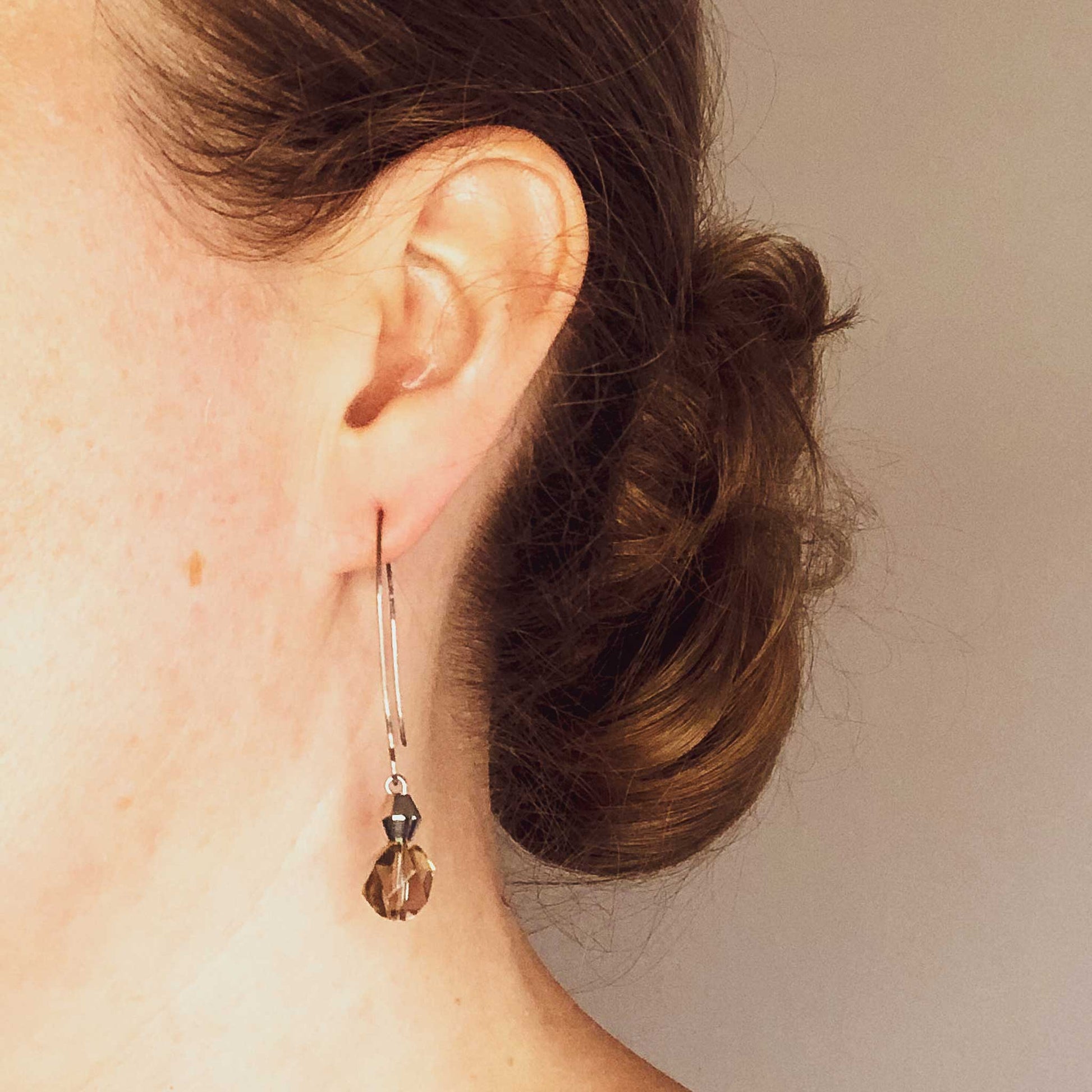 Woman wearing long Smoky Quartz earrings.