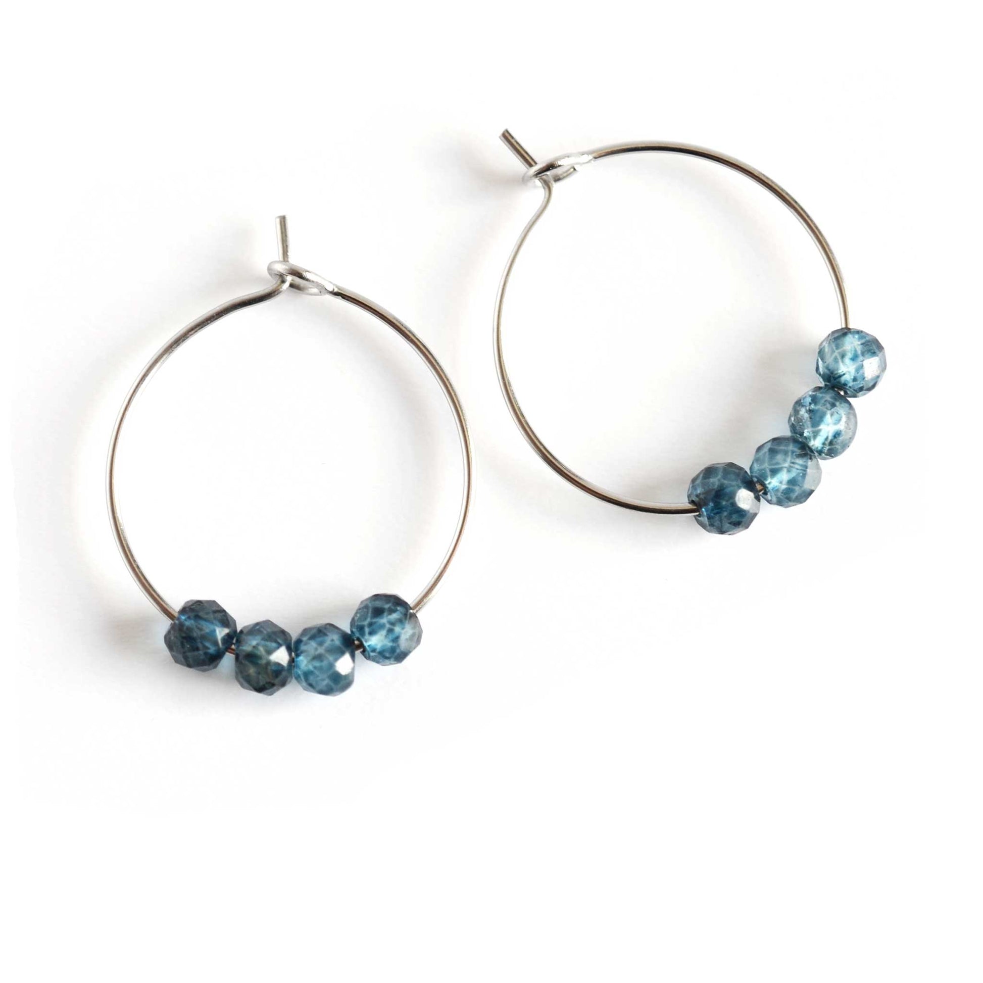 Pair of blue Topaz hoop earrings with hypoallergenic surgical steel hoops on white background