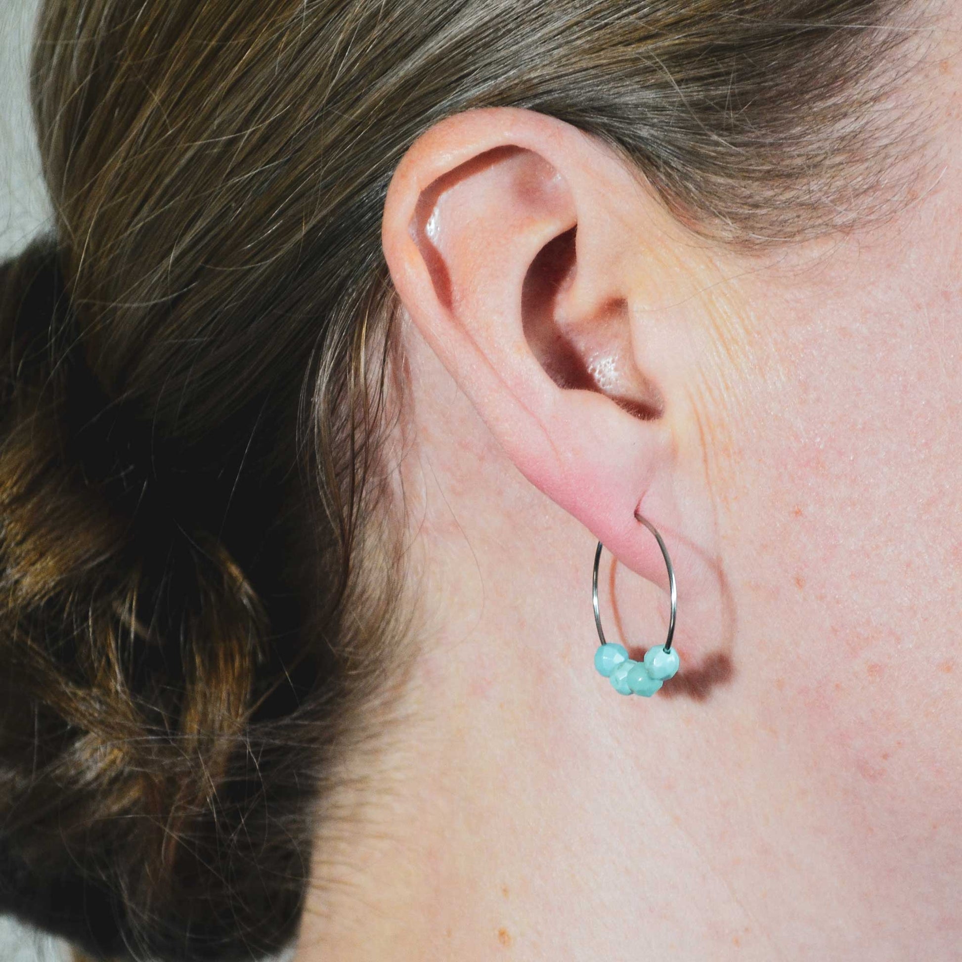 Woman wearing Turquoise hoop earrings in earlobe