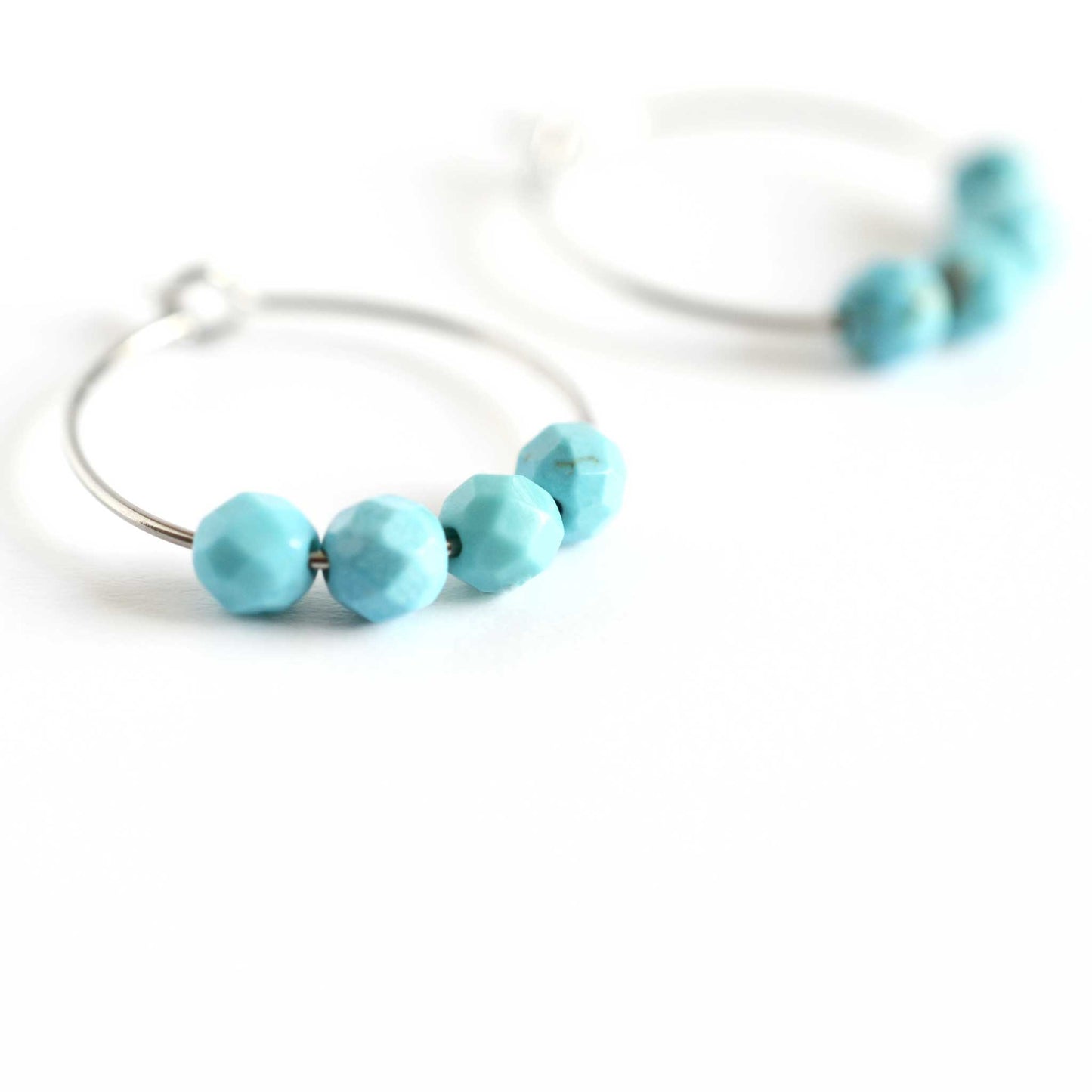 Close up image of Turquoise hoops with four faceted round Turquoise gemstone beads