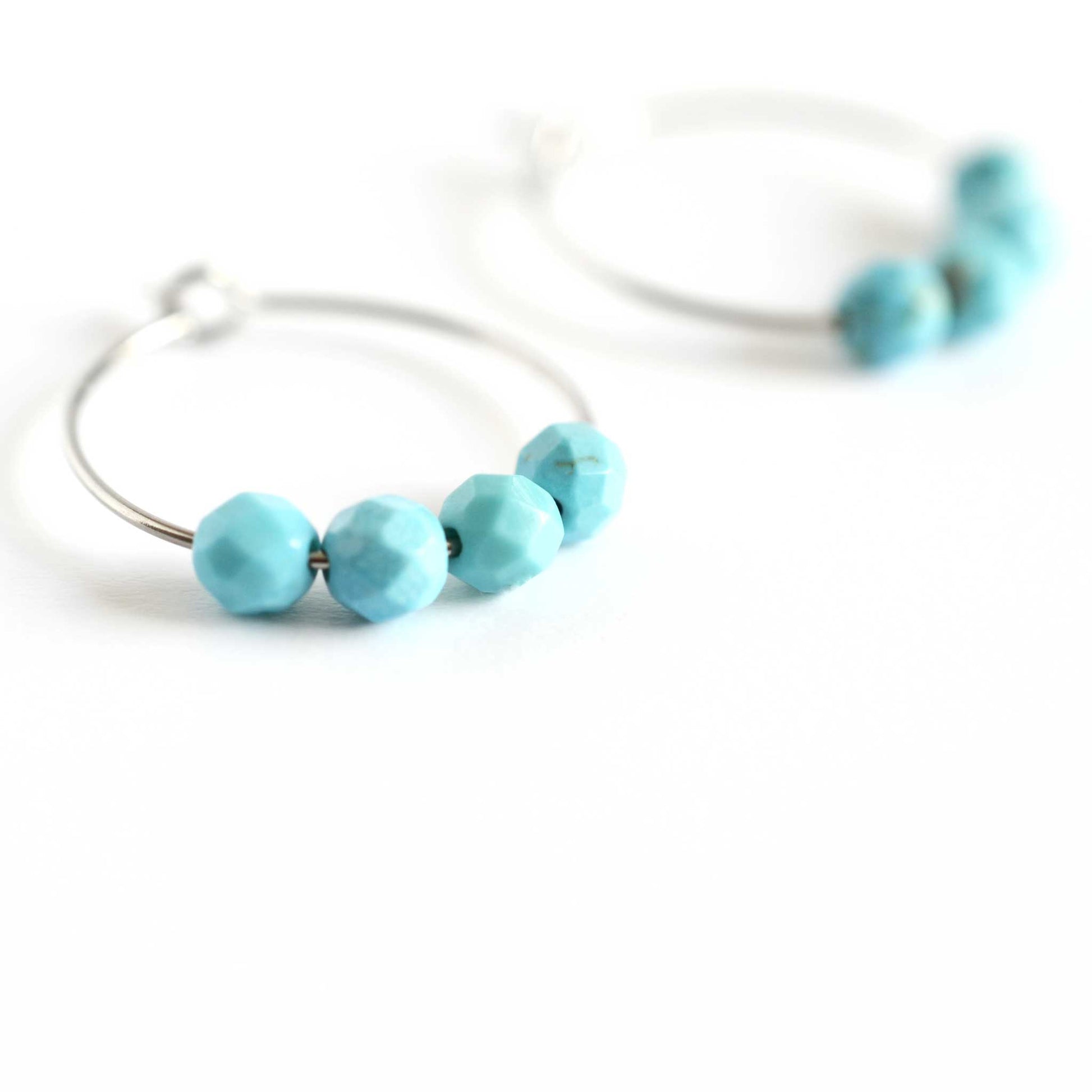 Close up image of Turquoise hoops with four faceted round Turquoise gemstone beads