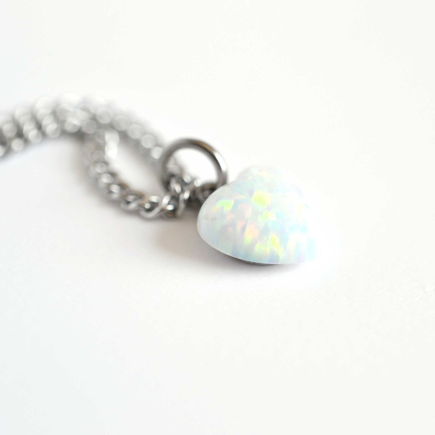 Side close up view of lab created white Opal heart pendant