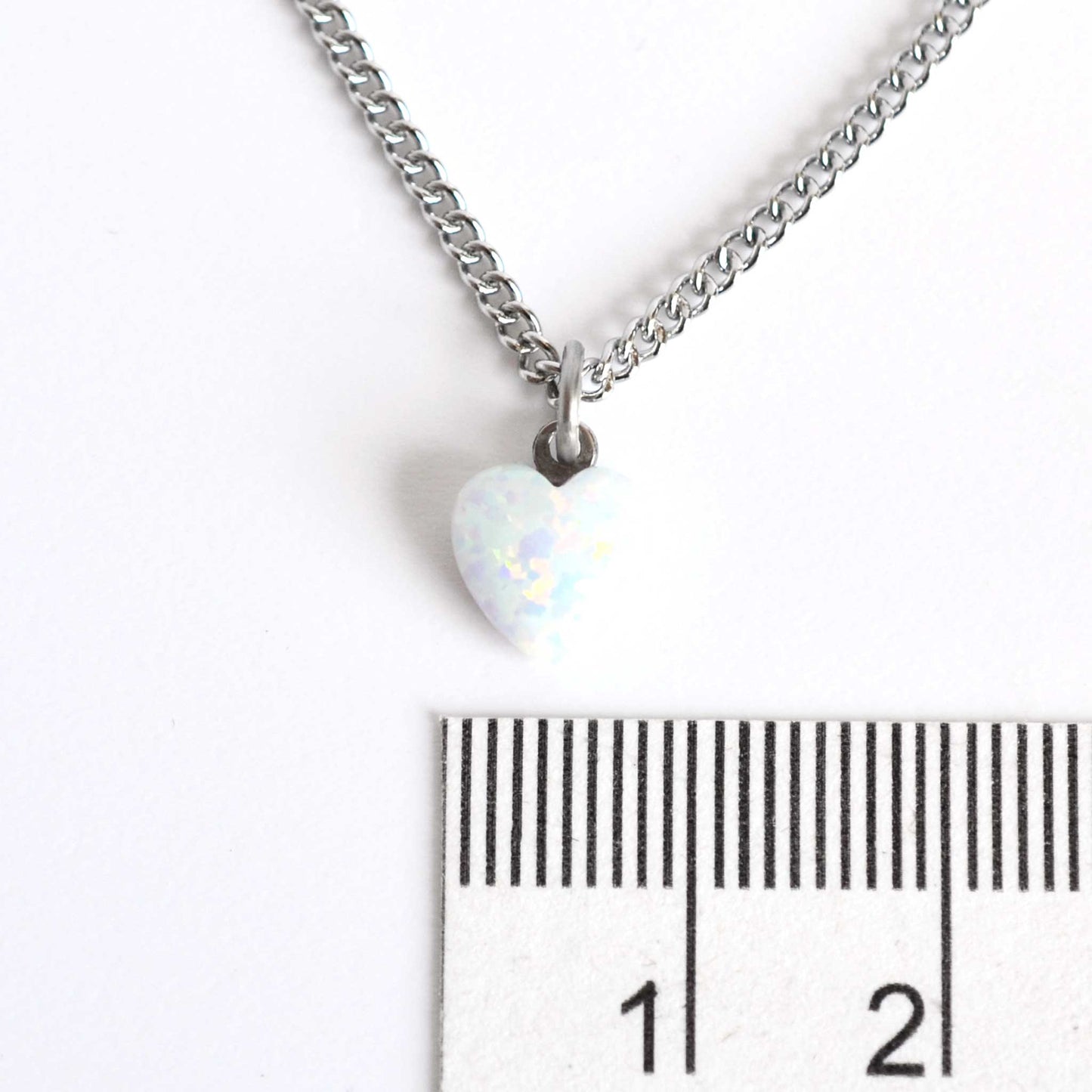8mm dainty white Opal heart necklace next to ruler