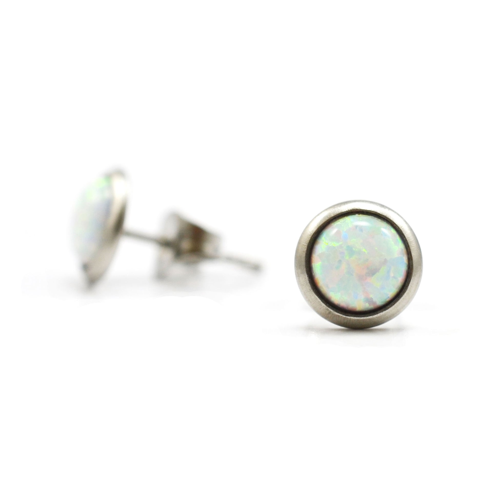 Round white Opal stud earrings on white background